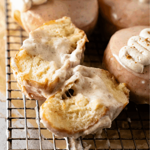 Golden fried chai custard donuts on a wire rack cooling before glazing