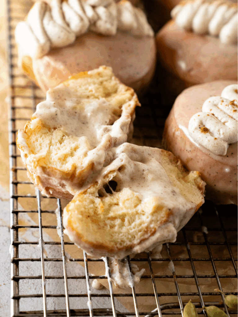 Golden fried chai custard donuts on a wire rack cooling before glazing