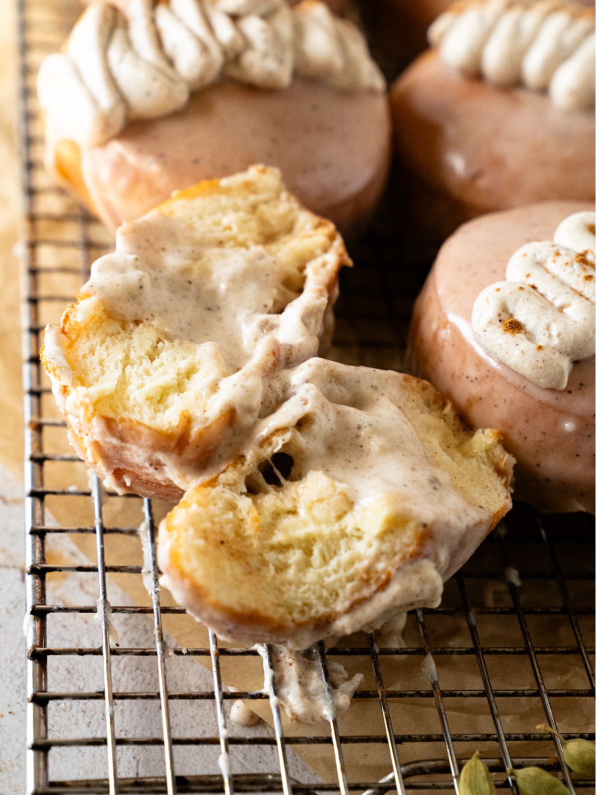Golden fried chai custard donuts on a wire rack cooling before glazing