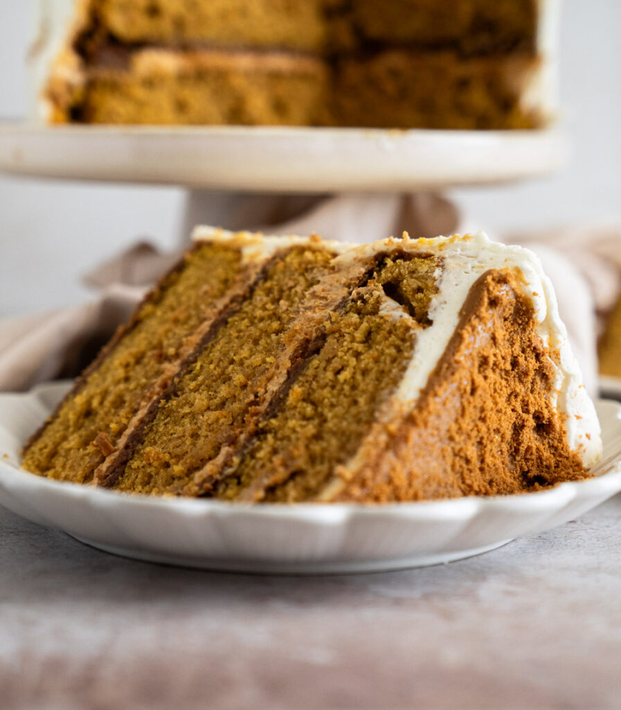 Pumpkin cake batter being mixed in a large mixing bowl with paddle attachment