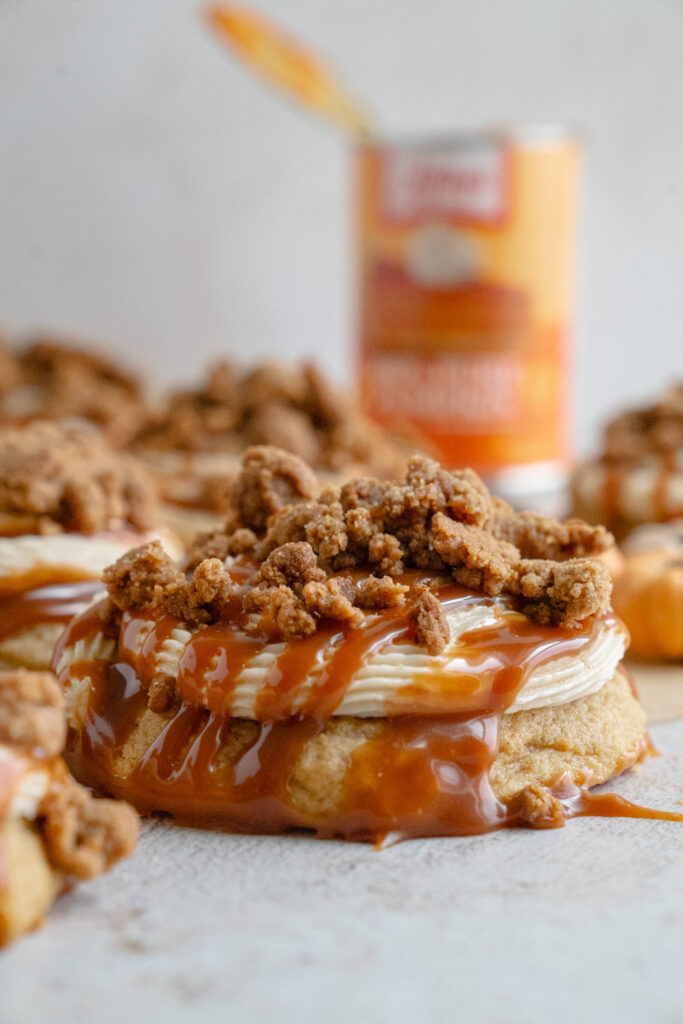 Stack of soft pumpkin caramel cookies showing fluffy texture with frosting and caramel topping.